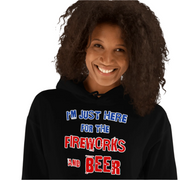 Woman wearing "I'm Just Here for the Fireworks and Beer" cozy black hoodie with a joyful smile.