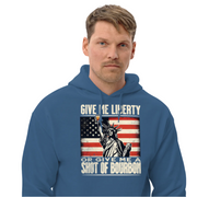 Hoodie with Give Me Liberty or Give Me a Shot of Bourbon text, Statue of Liberty holding a shot glass, and distressed American flag background. Perfect for 4th of July.