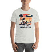 Man lounging in a beach chair with a cocktail, wearing our 'Sorry, Out of Office' vintage tee against a retro sunset backdrop.