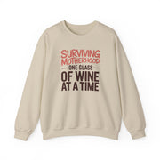 a beige sweatshirt with the phrase 'Surviving Motherhood One Glass of Wine at a Time' funny mother's day, mom life, girls trip design