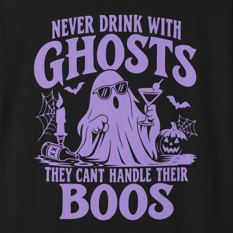 A black short-sleeve crewneck t-shirt with a purple graphic on the front. The graphic features a cartoon ghost holding a cocktail, surrounded by bats, a pumpkin, and spiderwebs, with the text 'NEVER DRINK WITH GHOSTS THEY CAN'T HANDLE THEIR BOOS'.