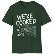 Funny Christmas Short Sleeve Shirt with a gingerbread man holding the oven door open with a sheetpan of gingerbread cookies and the text "We're Cooked" - Forest Green