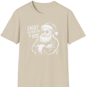 Funny Christmas Humor Short Sleeve Shirt with santa arms corssed and the text and the text "Easily Distracted By Hos" - Sand