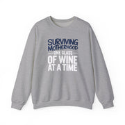 a gray sweatshirt with the phrase 'Surviving Motherhood One Glass of Wine at a Time' funny mother's day, mom life, girls trip design