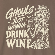 A brown long-sleeve t-shirt with a cream-colored graphic on the front featuring a skeleton woman holding a wine glass and the text 'Ghouls Just Wanna Drink Wine'.