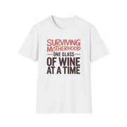 a white t-shirt with the phrase 'Surviving Motherhood One Glass of Wine at a Time' funny Mother's day, beach vacation, spring break design