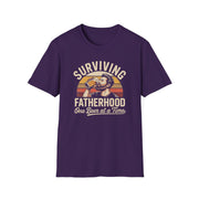 a funny purple t-shirt with the phrase 'Surviving Fatherhood One Beer at a Time" and a retro sunset graphic of a man drinking a beer funny father's day dad gift idea