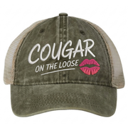 a olive green and khaki faded ponytail trucker cap with 'Cougar on the Loose' text and lipstick kiss mark funny spring break, beach vacation, summer vacation, lake season design.
