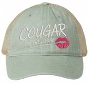 a green and khaki faded ponytail trucker cap with 'Cougar on the Loose' text and lipstick kiss mark funny spring break, beach vacation, summer vacation, lake season design.