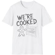 Funny Christmas Short Sleeve Shirt with a gingerbread man holding the oven door open with a sheetpan of gingerbread cookies and the text "We're Cooked" - White