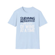 a light blue t-shirt with the phrase 'Surviving Motherhood One Glass of Wine at a Time' funny Mother's day, beach vacation, spring break design