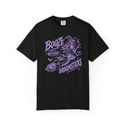 A black short-sleeve crewneck t-shirt with a purple graphic of a witch riding a broomstick, accompanied by the text 'BOOZE BEFORE BROOMSTICKS'.