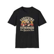a funny black t-shirt with the phrase 'Surviving Fatherhood One Beer at a Time" and a retro sunset graphic of a man drinking a beer funny father's day dad gift idea