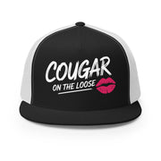 a black and white flat bill trucker hat with the phrase 'Cougar on the Loose' funny beach trip, girls trip, bachelorette party, or spring break design