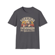 a funny gray t-shirt with the phrase 'Surviving Fatherhood One Beer at a Time" and a retro sunset graphic of a man drinking a beer funny father's day dad gift idea