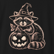 A black short-sleeve crewneck t-shirt featuring a graphic print of a raccoon wearing a witch hat and holding a carved jack-o'-lantern pumpkin