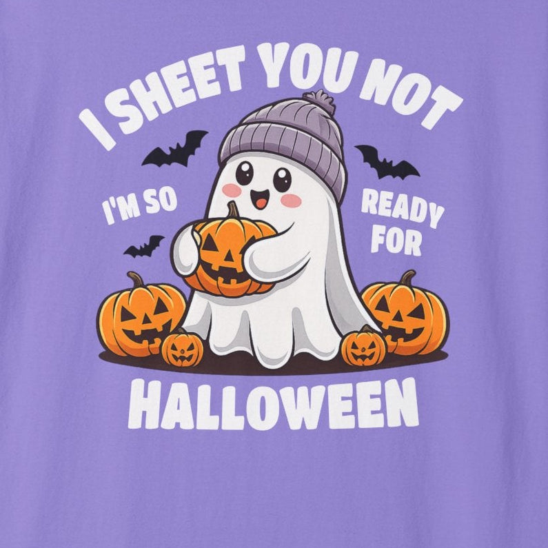 A purple short-sleeve crewneck t-shirt featuring a cartoon graphic of a ghost in a knit hat holding a pumpkin, surrounded by jack-o'-lanterns and bats, with the text 'I SHEET YOU NOT I'M SO READY FOR HALLOWEEN'.