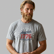 Man wearing a gray t-shirt with 'America 1776' design on a plain background