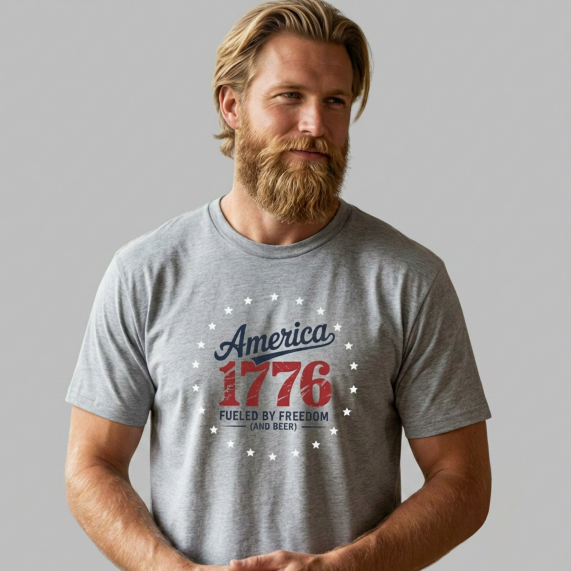 Man wearing a gray t-shirt with 'America 1776' design on a plain background