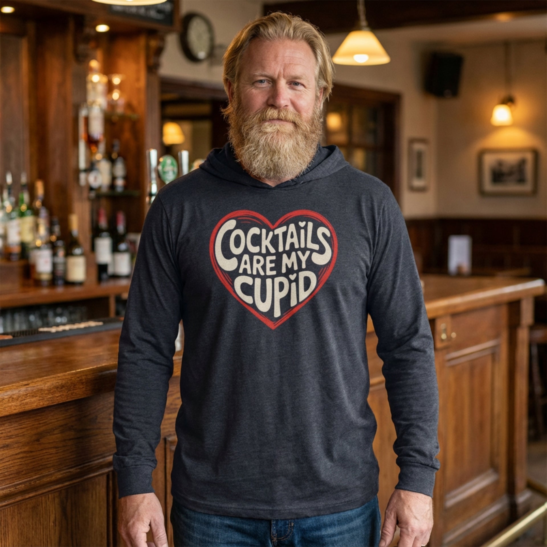 blond bearded male model wearing featherweight hoodie with the phrase "Cocktails are my cupid".  A minimalist valentine heart outline surrounds the phrase to complete the design
