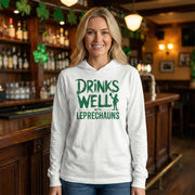 blonde woman wearing white lightweight St Patricks  Day hoodie with the Phrase “Drinks Well With Leprechauns”  with a leprechaun to complete the design