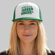Person wearing a cap with 'Fueled by Green Beer' text against a brick wall.