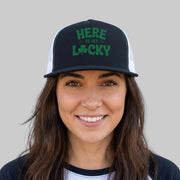 Person wearing a black and white cap with green text against a gray background