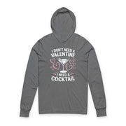 Gray featherweight hoodie with the phrase “I don’t need a valentine I need a cocktail” with an ink sketched wine glass and sketched valentine hearts to  complete the design