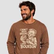A man wearing a brown long-sleeve graphic sweatshirt with a beige zombie holding a glass and the text 'I DON'T NEED BRAINS I HAVE BOURBON'.