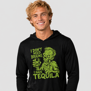 A smiling man wearing a black long-sleeve hoodie with a bright green zombie graphic and the text 'I DON'T NEED BRAINS I HAVE TEQUILA' on the front, photographed against a light gray studio background.