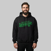 Man wearing a black hoodie with the phrase I'm here for the shenanigans funny st patricks day design