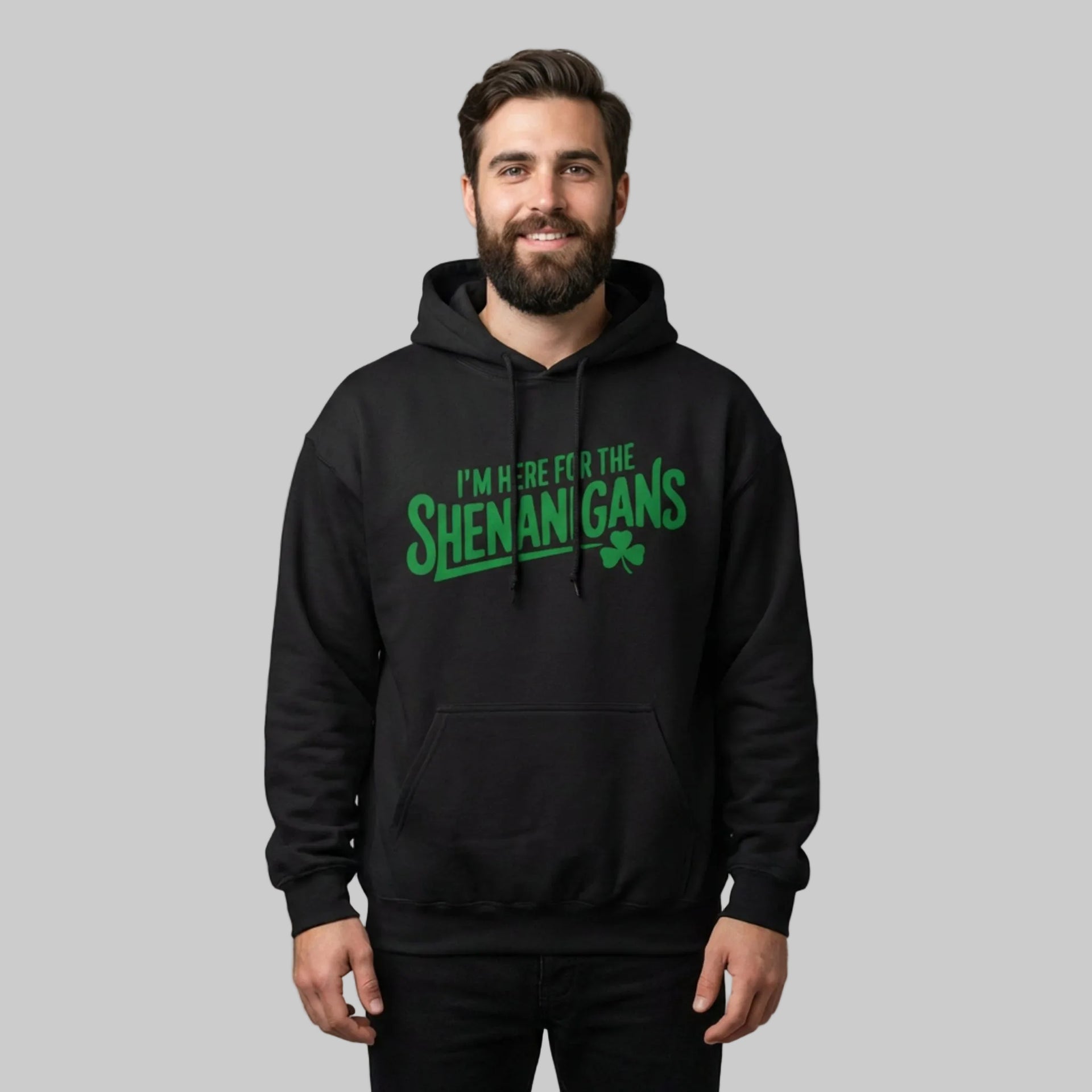 Man wearing a black hoodie with the phrase I'm here for the shenanigans funny st patricks day design