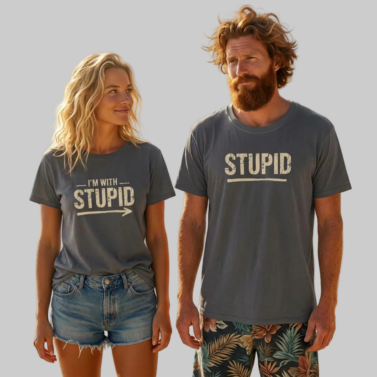 Two people on a beach wearing matching 'STUPID' t-shirts.