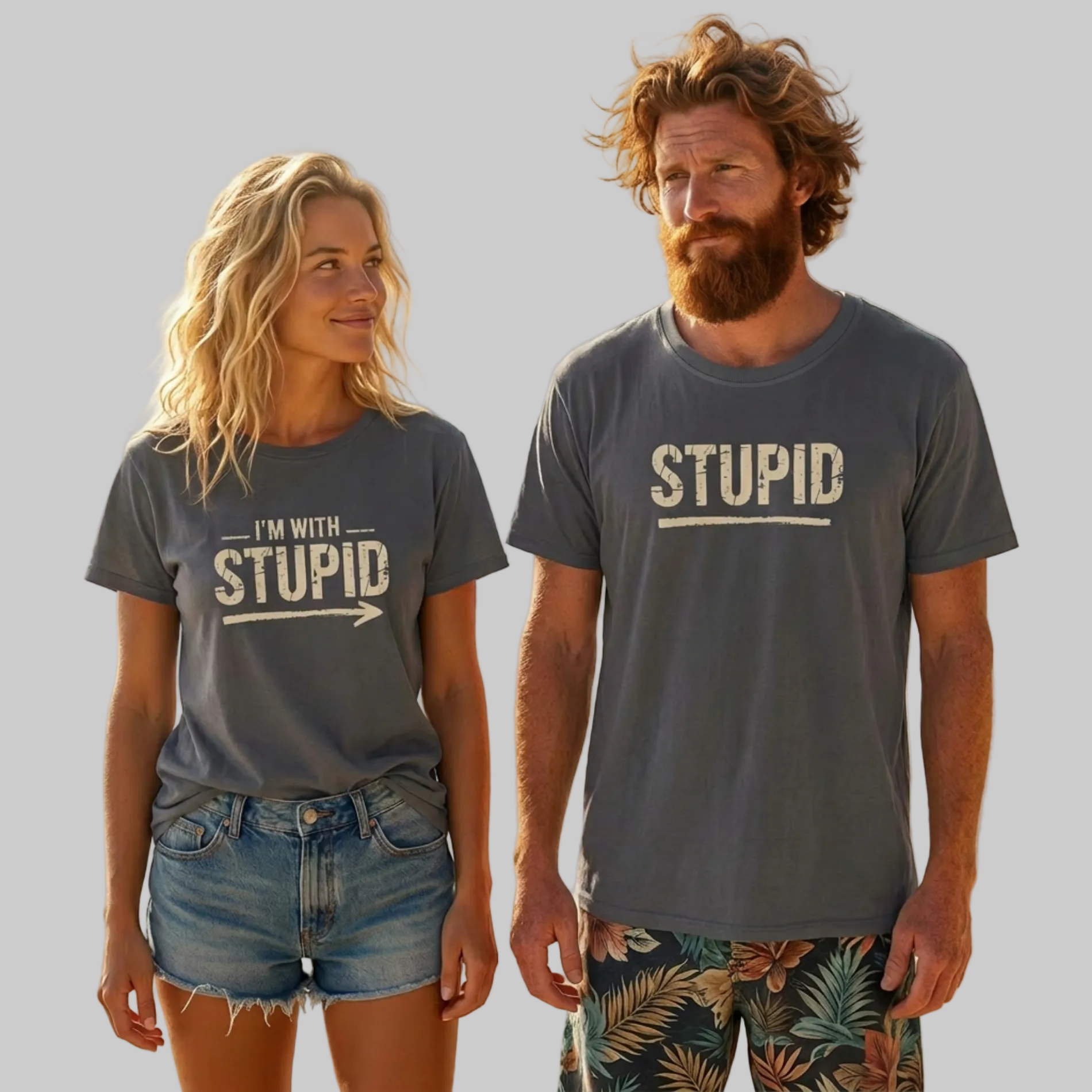 Two people on a beach wearing matching 'STUPID' t-shirts.