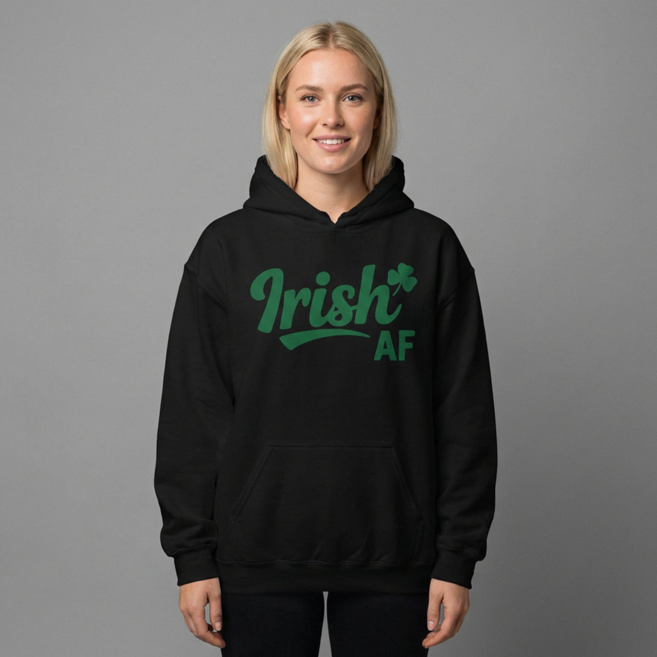 Woman wearing a Black hoodie with the phrase Irish AF funny St Patricks Day design