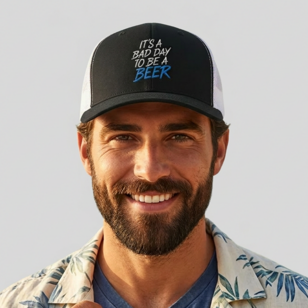 Man wearing a black and white trucker hat with teh phrase its a bad day to be a beer funny spring break, guys trip, girls trip, beach trip, lake season design