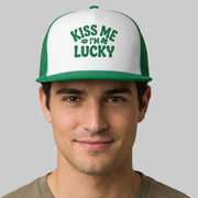 Man wearing a green and white cap with 'Kiss Me I'm Lucky' text on a gray background
