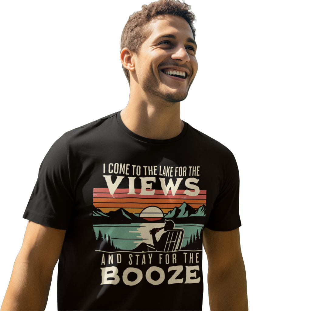 Tee showing "I Come to the Lake for the Views and Stay for the Booze," with a man in a beach chair, lake, and retro sunset.