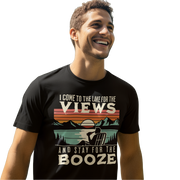 Tee showing "I Come to the Lake for the Views and Stay for the Booze," with a man in a beach chair, lake, and retro sunset.