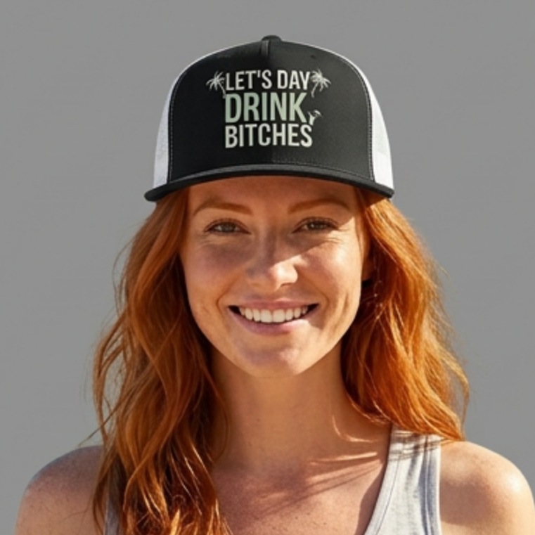 woman wearing a gray and white flat bill trucker hat with the text 'LET'S DAY DRINK BITCHES' printed on the front, featuring palm tree graphics.
