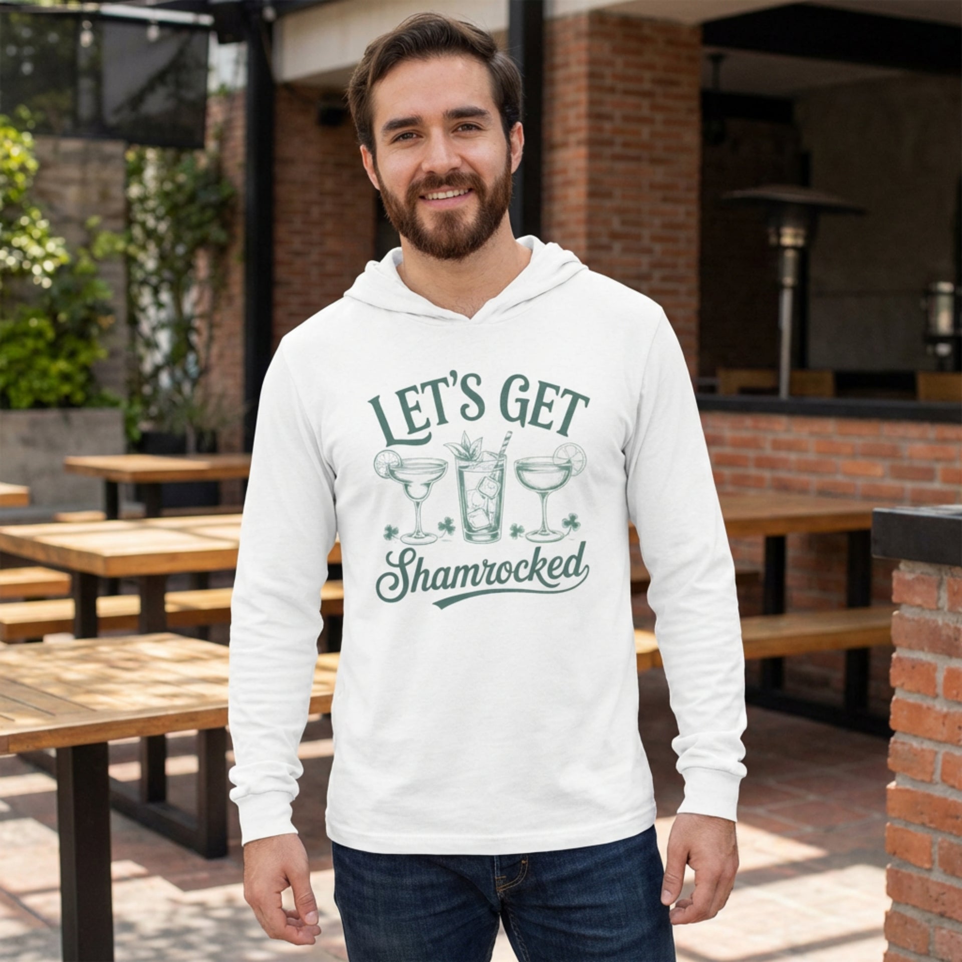 breaded brunette male wearing a white lightweight St Patricks  Day hoodie with the Phrase “Lets Get Shamrocked”  with a leprechaun smoking a cigar
