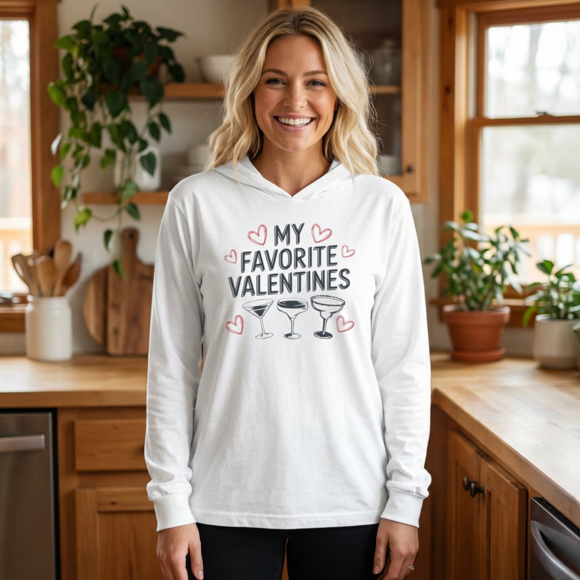 blonde female model wearing white  featherweight hoodie with the phrase "My Favorite Valentines".  Below the Phrase are three cocktail glasses. Minimalist Valentines Heart outlines surround the the phrase to complete the design
