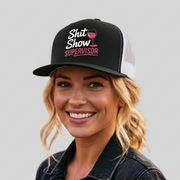 Woman wearing a black and white premium flat bill trucker hat with the phrase SHit Show Supervisor funny girls trip, beach vacation, spring break, summer vacations, lake days design