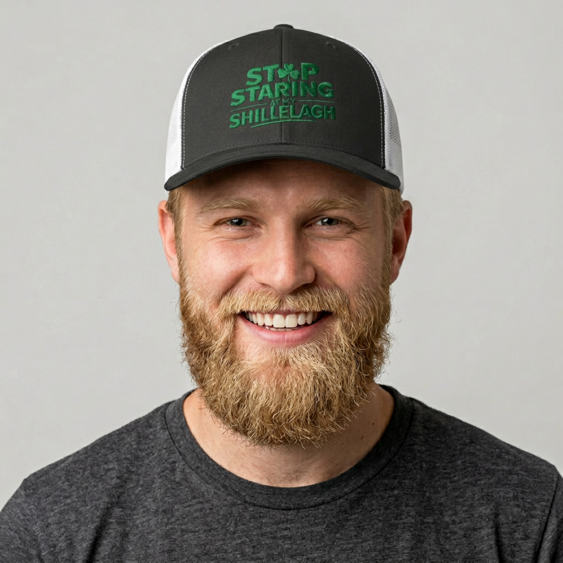 man wearing a black and white curved trucker hat with the phrase "Stop Staring at my Shillelagh" funny St Patricks Day pub crawl or parade design