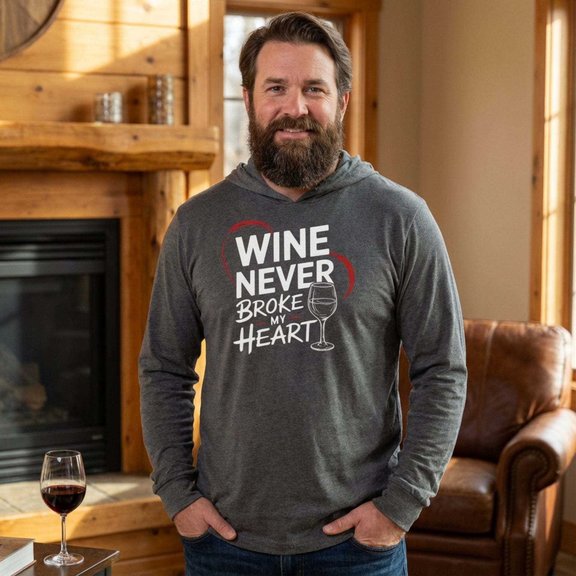 brunette male model wearing gray featherweight valentine's day hoodie with the Phrase "Wine Never Broke My Heart" surrounded by a sketched valentines heart and a wine glass graphic 
