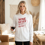 white featherweight valentine's day hoodie with the Phrase "Wine Never Broke My Heart" surrounded by a sketched valentines heart and a wine glass graphic 

