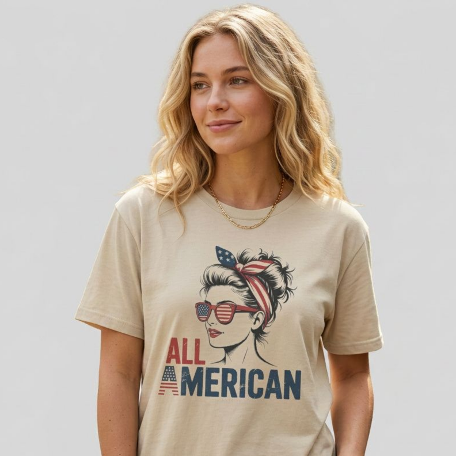 Woman wearing a beige t-shirt with 'All American' graphic design on a plain background