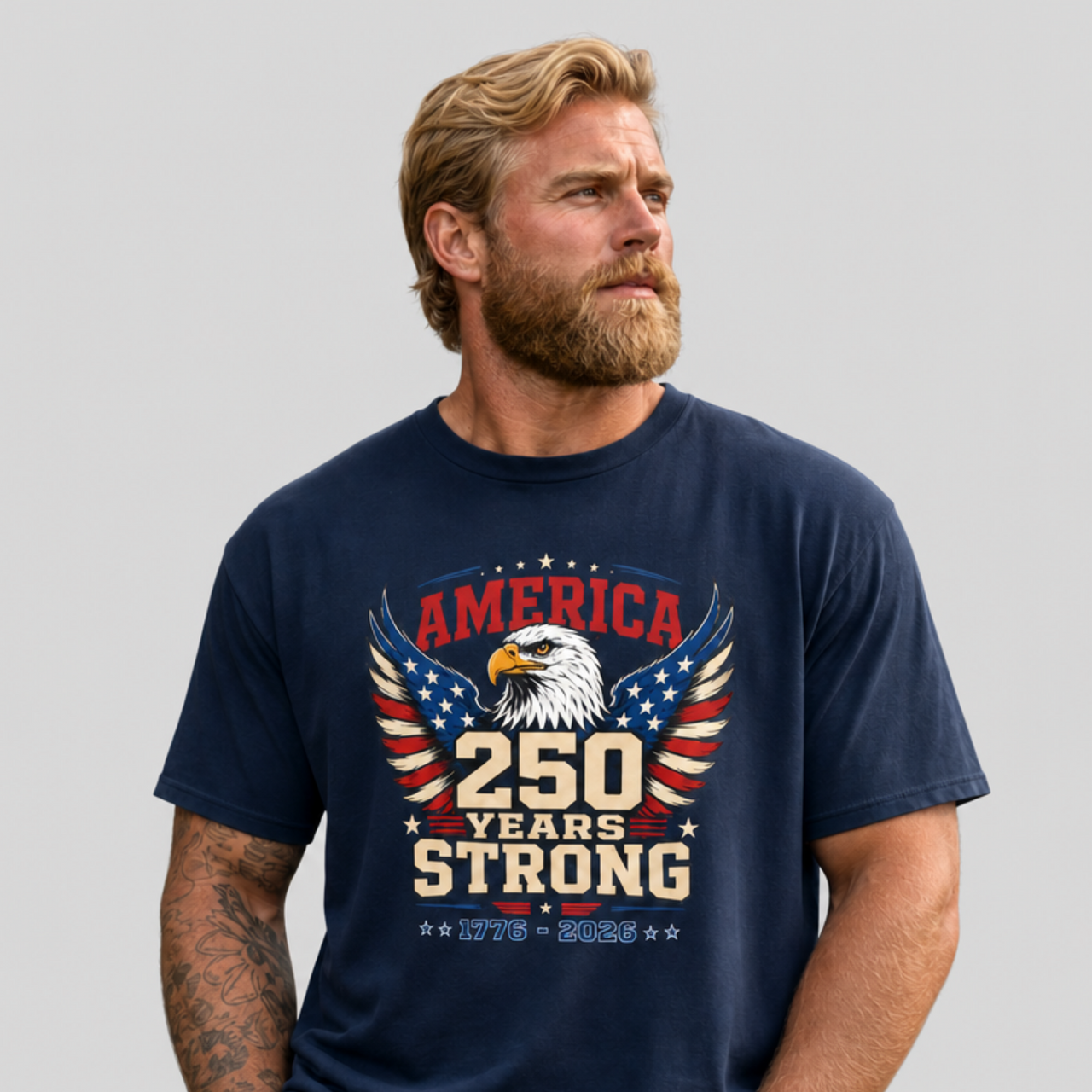 A man wearing a navy blue T-shirt with an eagle graphic and '250 Years Strong' text, patriotic 4th of July, America 250 design