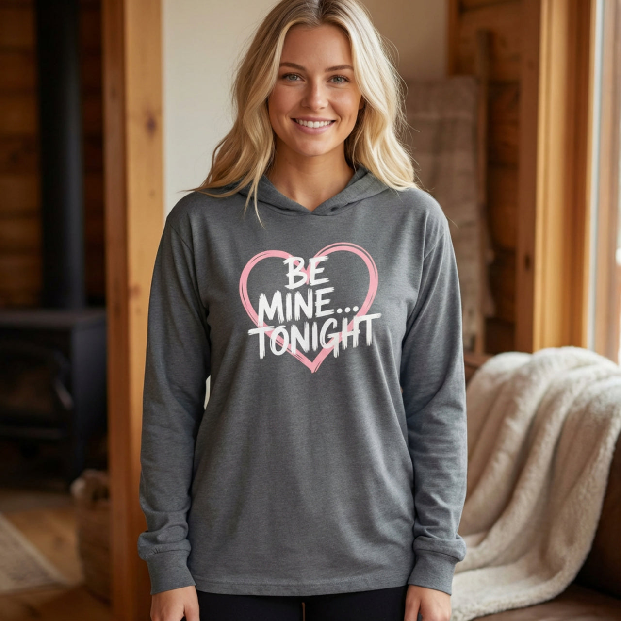 blonde female model wearing gray featherweight hoodie with the phrase "Be Mine... Tonight" with a minimalist sketched valentine's heart surrounding the phrase to complete the design
