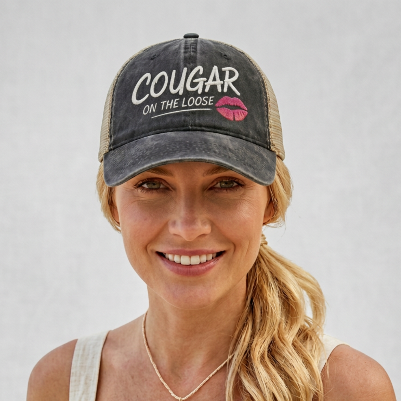 Woman wearing a balck and khaki faded ponytail trucker cap with 'Cougar on the Loose' text and lipstick kiss mark funny spring break, beach vacation, summer vacation, lake season design.